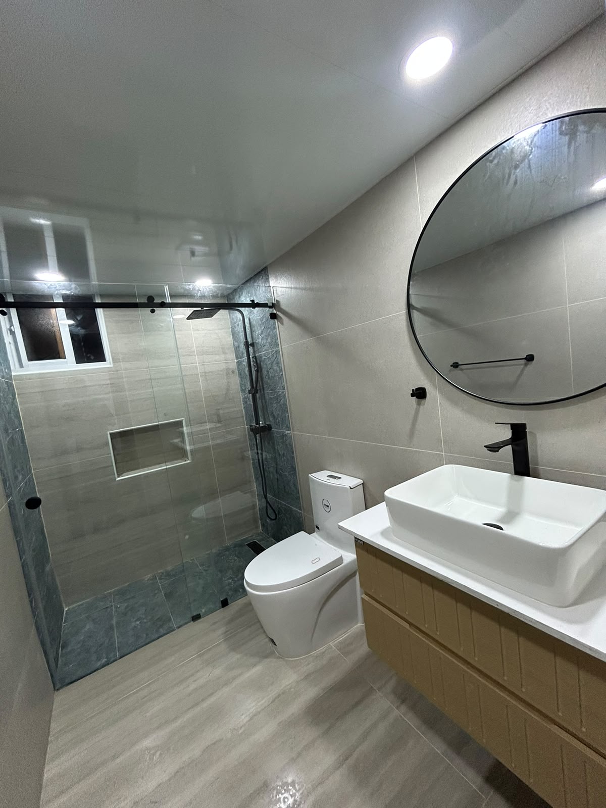 Baño en porcelanato beige con vanitorio de roble