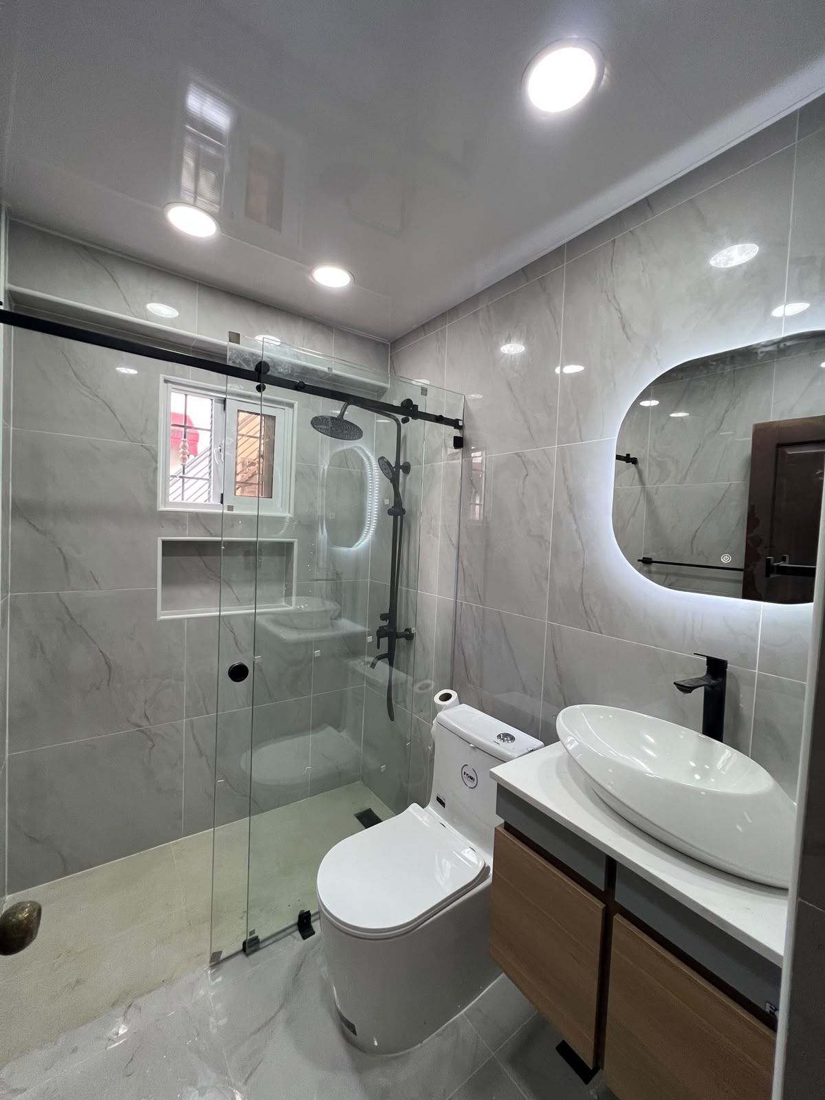 Ducha con vidrio templado y vanitorio en roble