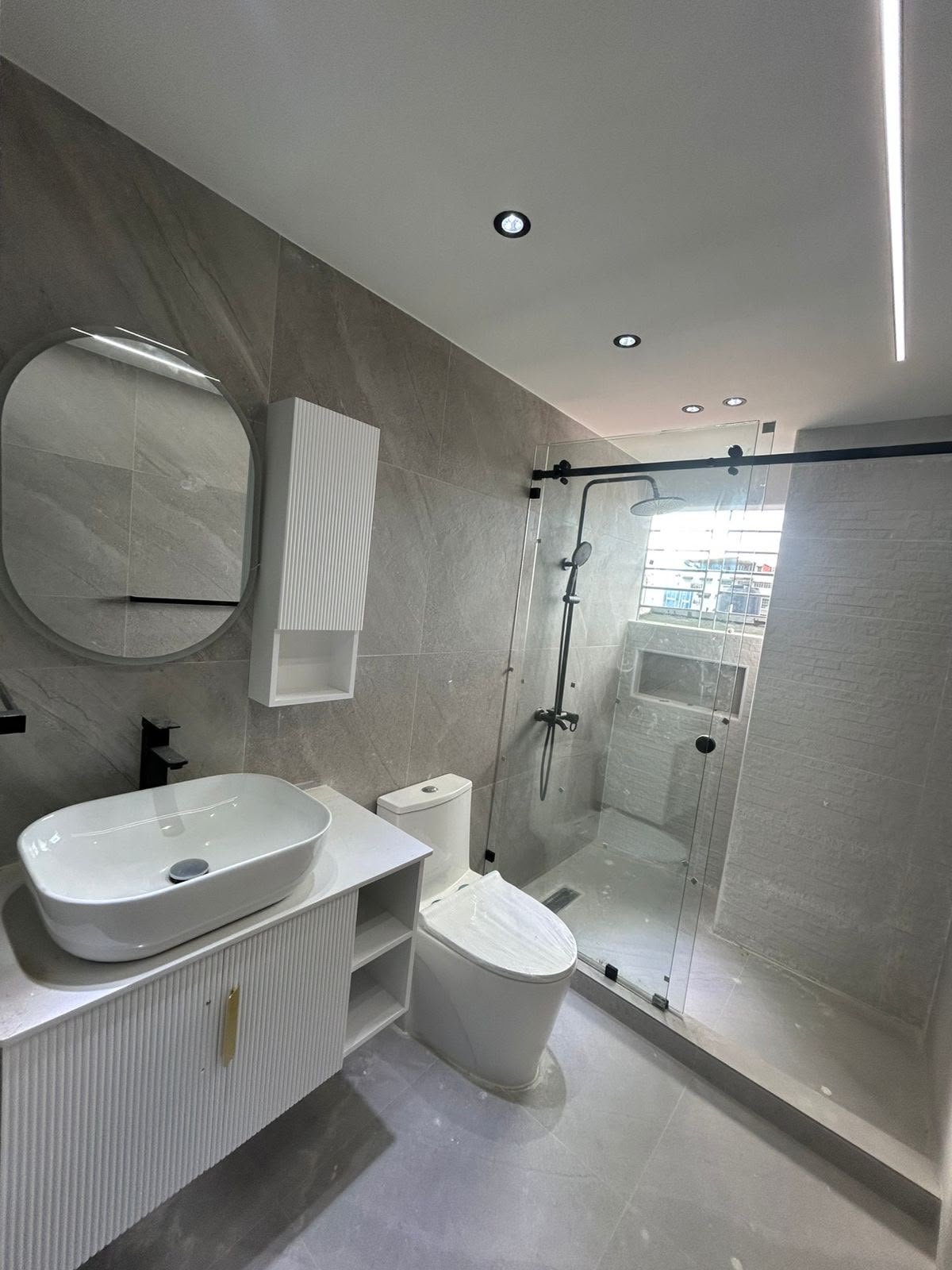 Baño en gris con mueble acanalado y botiquín